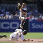 
              Milwaukee Brewers shortstop Luis Urias, above, hops over San Diego Padres' Jake Cronenworth, who slides into second base after being forced out during the seventh inning of a baseball game Wednesday, May 25, 2022, in San Diego. Manny Machado was safe at first on the play. (AP Photo/Gregory Bull)
            