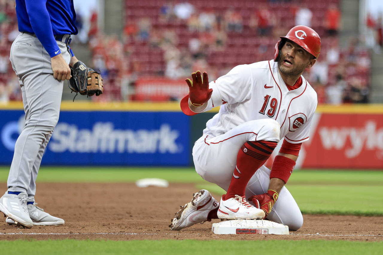 Cincinnati Reds' Joey Votto gestures for a timeout after hitting a two-run triple against the Chica...