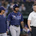 
              Tampa Bay Rays' Wander Franco, center, is escorted off the field by team staff after hitting a single in the ninth inning of a baseball game against the Texas Rangers, Monday, May 30, 2022, in Arlington, Texas. Franco suffered an unknown injury on the play. (AP Photo/Tony Gutierrez)
            
