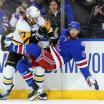 
              Pittsburgh Penguins' Jeff Carter (77) checks New York Rangers' Kevin Rooney (17) during the second period of Game 2 of an NHL hockey Stanley Cup first-round playoff series, Thursday, May 5, 2022, in New York. (AP Photo/Frank Franklin II)
            