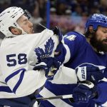 
              Toronto Maple Leafs left wing Michael Bunting (58) and Tampa Bay Lightning defenseman Zach Bogosian (24) scrap during the third period in Game 3 of an NHL hockey first-round playoff series Friday, May 6, 2022, in Tampa, Fla. (AP Photo/Chris O'Meara)
            