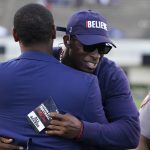 
              Jackson State football coach Deion Sanders, right, hugs athletic director Ashley Robinson following the school's Blue and White Spring football game, an NCAA college football contest, Sunday, April 24, 2022, in Jackson, Miss. (AP Photo/Rogelio V. Solis)
            