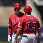 
              Los Angeles Angels designated hitter Shohei Ohtani, left, talks with first base coach Benji Gil (89) after hitting a single during the fifth inning of the first baseball game of a doubleheader against the Oakland Athletics in Oakland, Calif., Saturday, May 14, 2022. (AP Photo/Jeff Chiu)
            