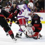 
              New York Rangers' Ryan Strome (16) drives the puck between Carolina Hurricanes' Brady Skjei (76) and Brett Pesce (22) only to have it blocked by goaltender Antti Raanta (32) during the first period of Game 1 of an NHL hockey Stanley Cup second-round playoff series in Raleigh, N.C., Wednesday, May 18, 2022. (AP Photo/Karl B DeBlaker)
            