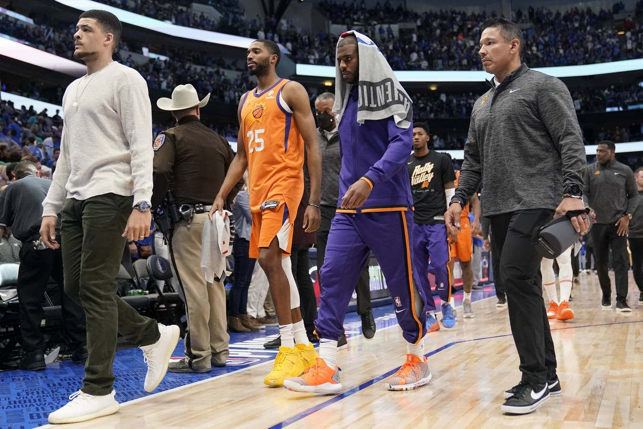 Phoenix Suns forward Mikal Bridges (25) and guard Chris Paul, second from right, walk off the court...