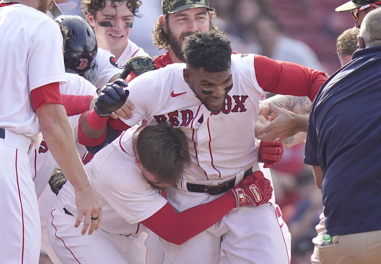 Boston Red Sox's Franchy Cordero, center, celebrates with teammates after hitting a grand slam in t...