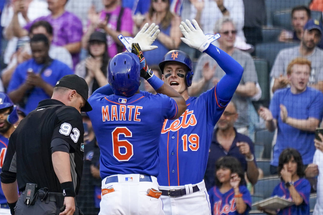 New York Mets' Starling Marte (6) and Mark Canha (19) celebrate after scoring nf Marte's two-run ho...