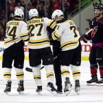 
              Boston Bruins' Hampus Lindholm (27) is helped from the ice by Jake DeBrusk (74) and Taylor Hall (71) as Carolina Hurricanes' Jordan Staal (11) watches during the second period of Game 2 of an NHL hockey Stanley Cup first-round playoff series in Raleigh, N.C., Wednesday, May 4, 2022. (AP Photo/Karl B DeBlaker)
            