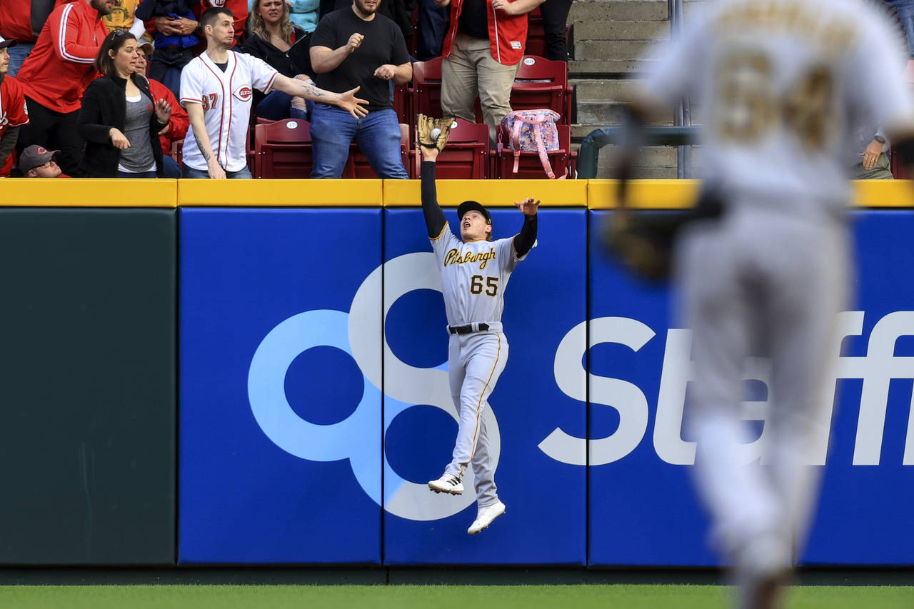 Pittsburgh Pirates' Jack Suwinski leaps to makes a catch at the outfield wall on a ball hit by Cinc...