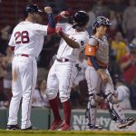 
              Boston Red Sox's J.D. Martinez, left, celebrates with Xander Bogaerts, center, after they both scored on a two-run home run by Bogaerts in the eighth inning of a baseball game, as Houston Astros' Jason Castro, right, looks on, Monday, May 16, 2022, in Boston. The Red Sox won 6-3. (AP Photo/Steven Senne)
            