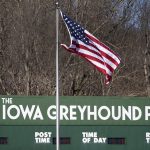 
              A flag flys over the Iowa Greyhound Park, Saturday, April 16, 2022, in Dubuque, Iowa. After the end of a truncated season in Dubuque in May, the track here will close. By the end of the year, there will only be two tracks left in the country. (AP Photo/Charlie Neibergall)
            