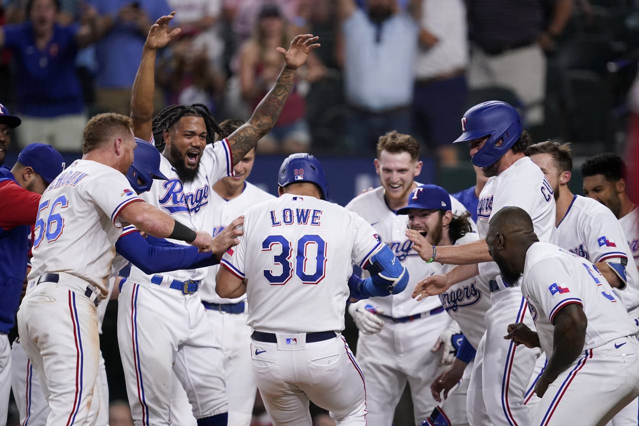The Texas Rangers celebrate a walk-off, two-run home run hit by Nathaniel Lowe (30) during the 10th...
