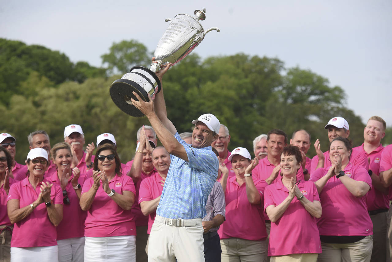 Steven Alker, center, raises the Alfred S. Bourne Trophy, Sunday, May 29, 2022, after winning the S...
