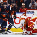 
              Calgary Flames goalie Jacob Markstrom, right, dives for the puck as Edmonton Oilers center Ryan Nugent-Hopkins (93) scores during the third period of Game 4 of an NHL hockey Stanley Cup playoffs second-round series Tuesday, May 24, 2022, in Edmonton, Alberta. (Jeff McIntosh/The Canadian Press via AP)
            