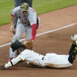 
              St. Louis Cardinals third baseman Nolan Arenado, top front, tags out Pittsburgh Pirates' Rodolfo Castro, bottom, attempting to steal third during the fifth inning of a baseball game in Pittsburgh, Friday, May 20, 2022. (AP Photo/Gene J. Puskar)
            