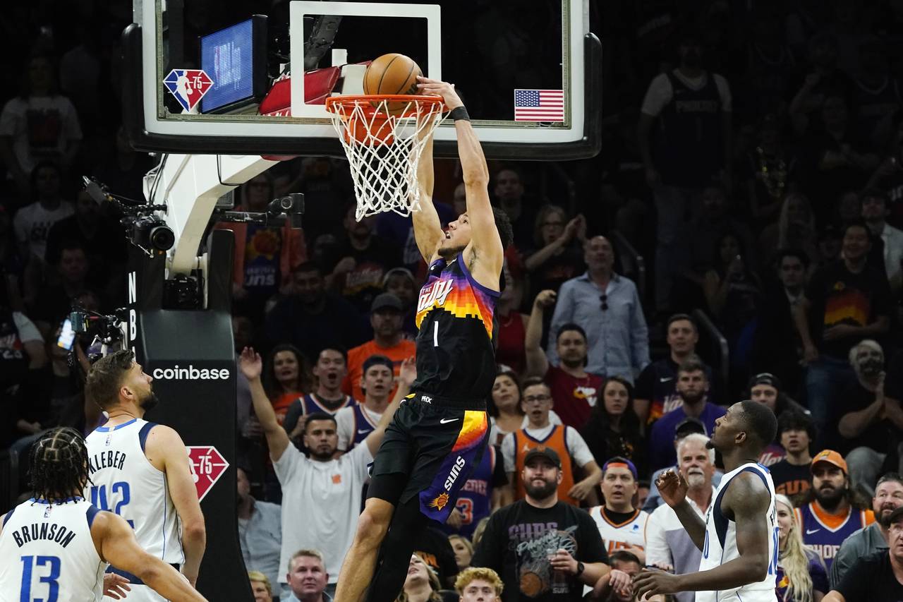 Phoenix Suns guard Devin Booker (1) dunks against Dallas Mavericks guard Jalen Brunson (13), Maveri...