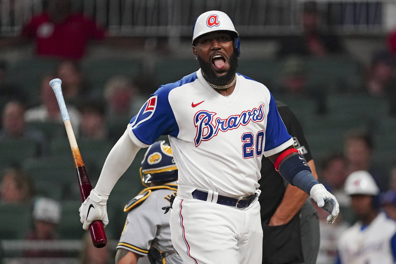 Atlanta Braves' Marcell Ozuna reacts after foul-tipping a pitch in the seventh inning of a baseball...