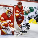 
              Dallas Stars forward Joe Pavelski, right, tries to get the puck past Calgary Flames goalie Jacob Markstrom, left, as forward Trevor Lewis checks him during first period NHL playoff hockey action in Calgary, Alberta, Sunday, May 15, 2022. (Jeff McIntosh/The Canadian Press via AP)
            