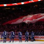 
              Fans and players stand for the national anthems before Game 2 of an NHL hockey Stanley Cup playoffs first-round series between the Tampa Bay Lightning and the Toronto Maple Leafs on Wednesday, May 4, 2022, in Toronto. (Frank Gunn/The Canadian Press via AP)
            