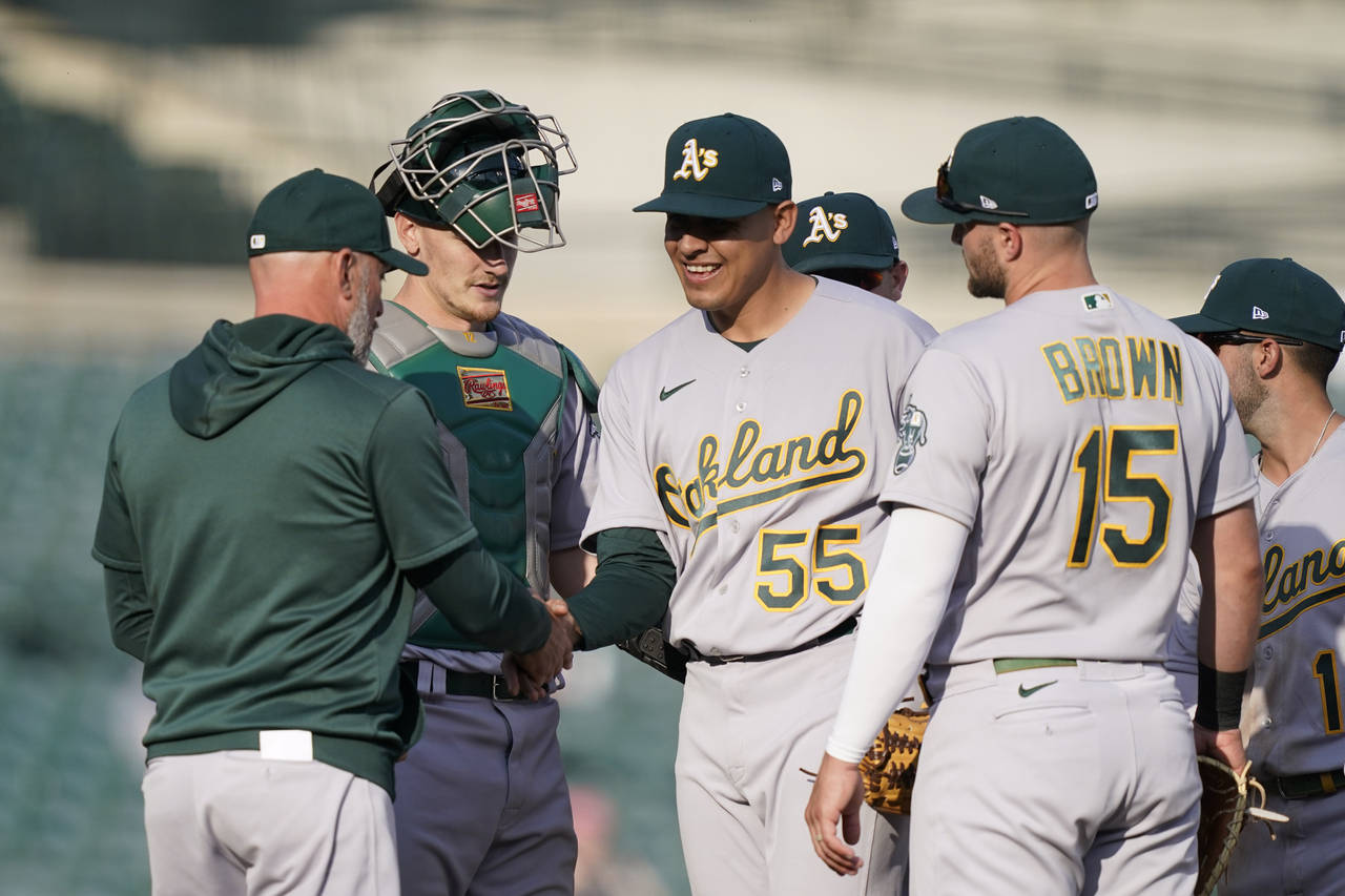 Oakland Athletics starting pitcher Adrian Martinez hands the ball to manager Mark Kotsay during the...
