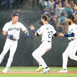 SEATTLE, WASHINGTON - JUNE 11: Dylan Moore #25 of the Seattle Mariners is doused with water by Jesse Winker #27 and J.P. Crawford #3 after hitting a walk-off RBI single to defeat the Boston Red Sox by a score of 7-6 during the ninth inning at T-Mobile Park on June 11, 2022 in Seattle, Washington. (Photo by Abbie Parr/Getty Images)
