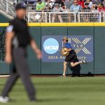 
              Grounds crew member removes a beach ball from left field in the game between Arkansas and Mississippi in the third inning during an NCAA College World Series baseball game Wednesday, June 22, 2022, in Omaha, Neb. (AP Photo/John Peterson)
            