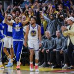 
              Fans and the Golden State Warriors' bench reacts after Stephen Curry, 30, hit a three point shot during the third quarter of Game 2 of basketball's NBA Finals against the Boston Celtics in San Francisco, on Sunday, June 5, 2022.  (Carlos Avila Gonzalez/San Francisco Chronicle via AP)
            