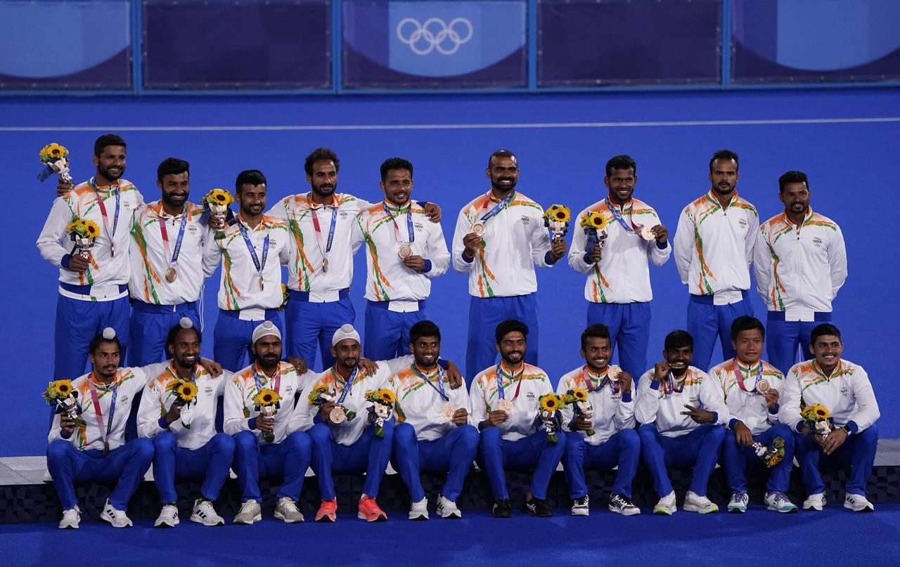 FILE - The India field hockey team poses for a photo with their bronze medal after taking third pla...