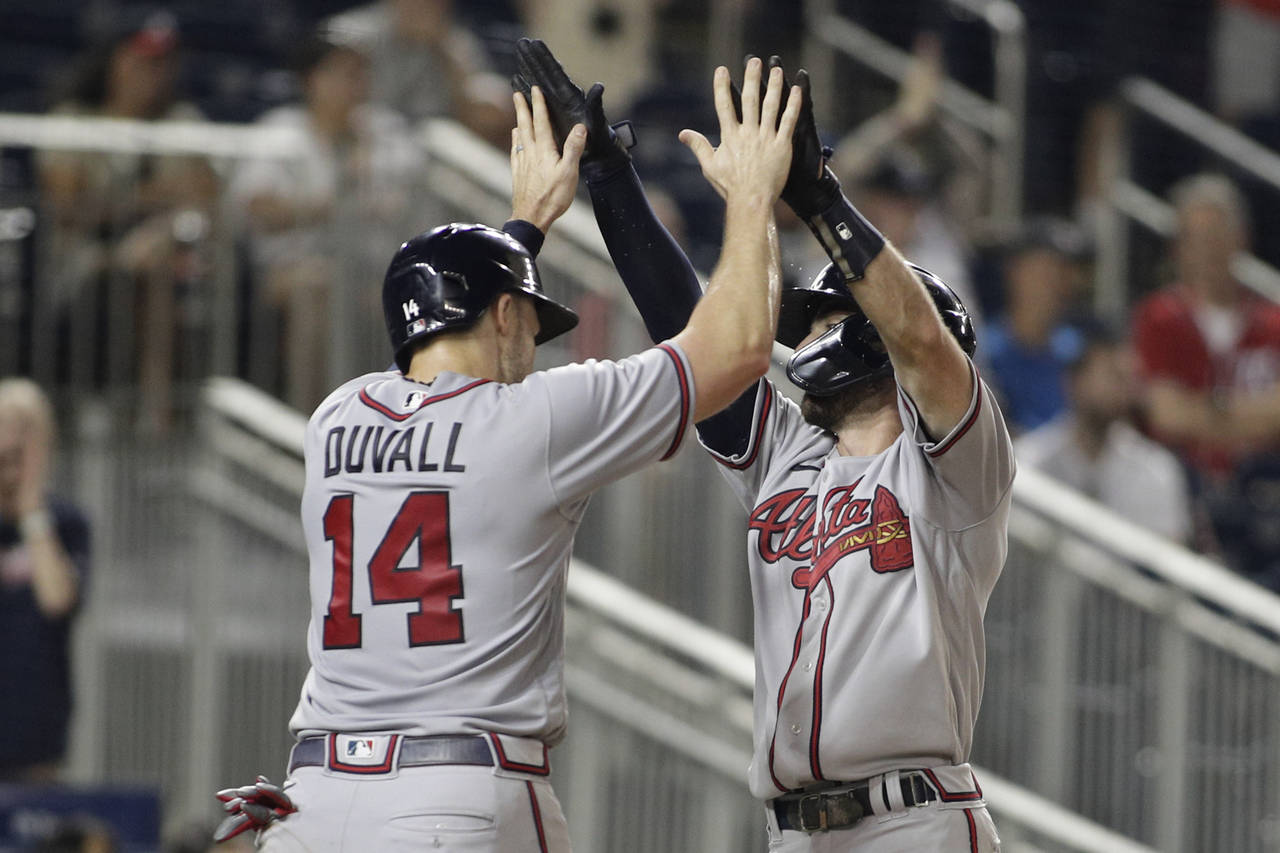Atlanta Braves' Dansby Swanson, right, celebrates his two-run home run with teammate Adam Duvall (1...