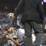 
              Umpire Alan Porter, top, watches as Colorado Rockies catcher Elias Diaz holds the ball after tagging out San Francisco Giants' Luis Gonzalez at home during the fifth inning of a baseball game in San Francisco, Wednesday, June 8, 2022. (AP Photo/Jeff Chiu)
            