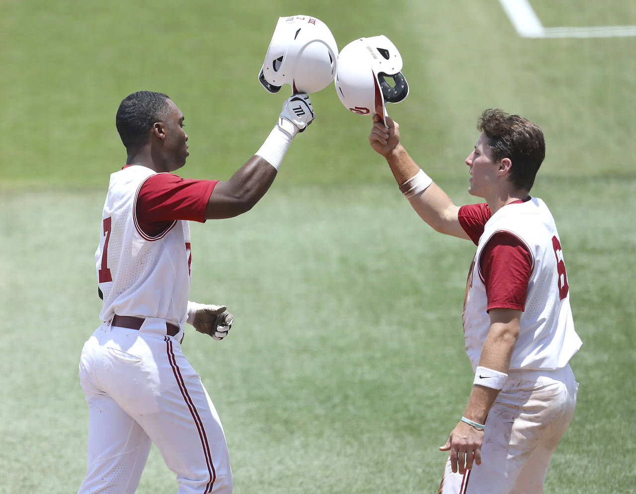 Oklahoma Kendall Pettis (7) and Wallace Clark (6) celebrate after Pettis hit a home run against Lib...