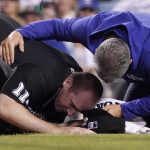 
              Home plate umpire Nate Tomlinson, left, is helped by a Los Angeles Dodgers trainer after he was hit in the face by a broken bat as Los Angeles Angels' Mike Trout hit a single during the ninth inning of a baseball game Tuesday, June 14, 2022, in Los Angeles. (AP Photo/Mark J. Terrill)
            