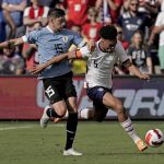
              USA defender Antonee Robinson (5) and Uruguay midfielder Federico Valverde (15) chase the ball during the second half of an international friendly soccer match Sunday, June 5, 2022, in Kansas City, Kan. The match ended in a 0-0 tie. (AP Photo/Charlie Riedel)
            