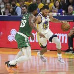 
              Golden State Warriors guard Stephen Curry (30) brings the ball up the court against Boston Celtics guard Marcus Smart during the first half of Game 1 of basketball's NBA Finals in San Francisco, Thursday, June 2, 2022. (AP Photo/Jed Jacobsohn)
            