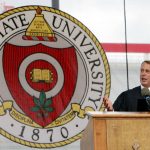 
              FILE- Then Speaker of the U.S. House of Representatives John A. Boehner from Ohio, addresses students as he stands beside The Ohio State University crest during commencement exercises on June 12, 2011, in Columbus, Ohio. Ohio State University has won its fight to trademark the word "The." The U.S. Patent and Trademark Office approved the university's request Tuesday, June 21, 2022. The school says it allows Ohio State to control use of "The" on branded products associated with and sold through athletics and collegiate channels. (AP Photo/Terry Gilliam, File)
            
