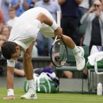 
              Serbia's Novak Djokovic touches the grass on Centre Court as he celebrates after beating Korea's Kwon Soonwoo in a men's first round singles match on day one of the Wimbledon tennis championships in London, Monday, June 27, 2022. (AP Photo/Kirsty Wigglesworth)
            