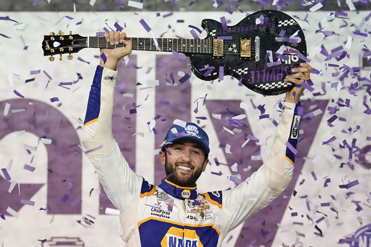 Chase Elliott holds the guitar presented to him after winning a NASCAR Cup Series auto race Sunday,...