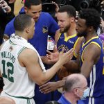 
              Boston Celtics forward Grant Williams (12) congratulates Golden State Warriors guard Stephen Curry (30) and forward Andrew Wiggins (22) after the Warriors defeated the Celtics in Game 6 of basketball's NBA Finals, Thursday, June 16, 2022, in Boston. (AP Photo/Michael Dwyer)
            