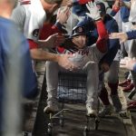
              Boston Red Sox's Bobby Dalbec is pushed trough the dugout in a towel cart by Kevin Plawecki after Dalbec hit a solo home run during the seventh inning of the team's baseball game against the Seattle Mariners, Friday, June 10, 2022, in Seattle. (AP Photo/Ted S. Warren)
            