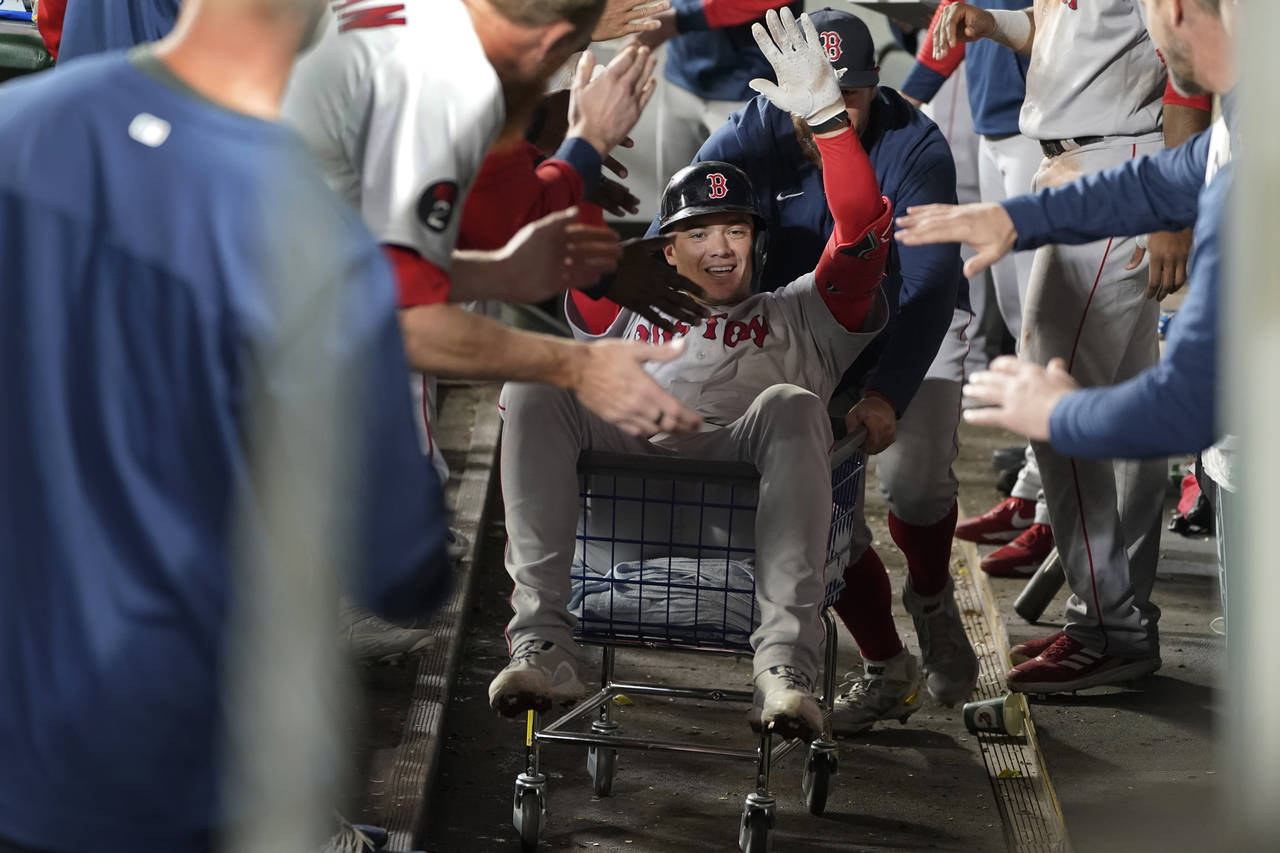 Boston Red Sox's Bobby Dalbec is pushed trough the dugout in a towel cart by Kevin Plawecki after D...