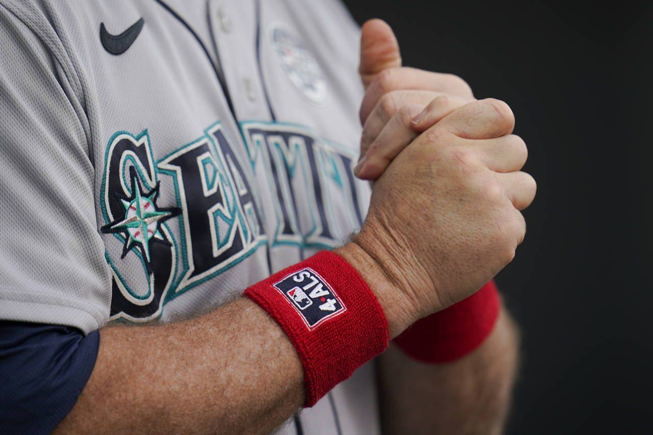 Seattle Mariners manager Scott Servais wears wrist bands in honor of Lou Gehrig Day prior to a base...
