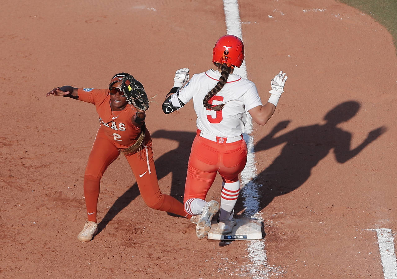 Texas' Janae Jefferson (2) makes the catch for an out before Oklahoma State's Kiley Naomi (5) can r...