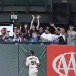 
              San Francisco Giants right fielder Luis Gonzalez (51) leans against the wall as fans reach for a home run hit by Los Angeles Dodgers' Freddie Freeman during the ninth inning of a baseball game in San Francisco, Saturday, June 11, 2022. (AP Photo/Jeff Chiu)
            
