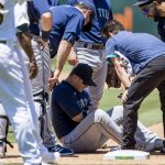 
              Seattle Mariners first baseman Ty France, on ground, is attended to after he sustained an injury as Oakland Athletics' Sheldon Neuse. not seen, reached first base on a single during the fifth inning of a baseball game in Oakland, Calif., Thursday, June 23, 2022. (AP Photo/John Hefti)
            