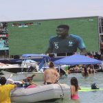 
              FILE - Soccer fans cool off in the water as they watch a broadcast of France playing Croatia in the World Cup soccer as they attend the "Ballyhoo Boat Bash" at the Haulover Sandbar in Miami, on July 15, 2018. .S. cities and states have lined up with tax breaks and millions of dollars in both public and private investments for a chance at hosting 2026 FIFA World Cup games, set to be announced Thursday, June 16, 2022.  (Carle Juste/Miami Herald via AP, File0
            