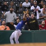 
              Texas Rangers' Ezequiel Duran waits to catch a pop foul by Cleveland Guardians' Andres Gimenez as a spectator tries to distract him during the sixth inning of the second game of a baseball doubleheader in Cleveland, Tuesday, June 7, 2022. (AP Photo/Phil Long)
            