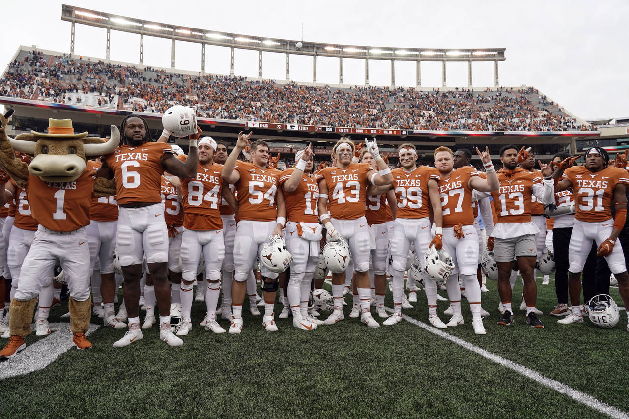 FILE - Texas players sing "The Eyes Of Texas" after defeating Kansas State in an NCAA college footb...