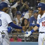
              Los Angeles Dodgers' Justin Turner, right, smiles after Mookie Betts scored on a single by Trea Turner against the New York Mets during the seventh inning of a baseball game Friday, June 3, 2022, in Los Angeles. (AP Photo/John McCoy)
            