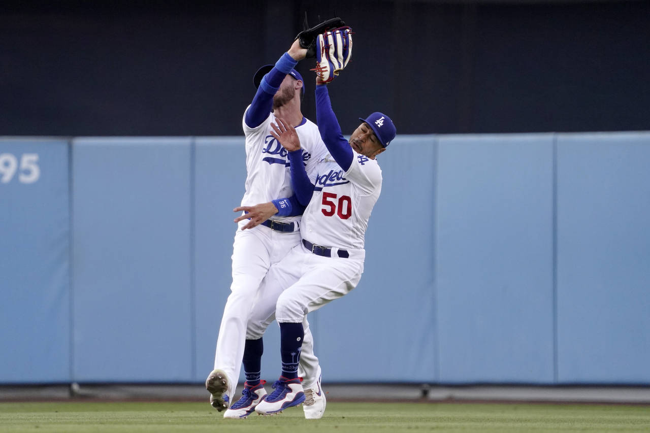 Los Angeles Dodgers right fielder Mookie Betts, right, collides with center fielder Cody Bellinger ...