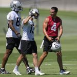 
              Las Vegas Raiders quarterback Derek Carr (4) speaks with tight end Darren Waller, left, and wide receiver Hunter Renfrow (13) at the NFL football team's practice facility Wednesday, June 8, 2022, in Henderson, Nev. (AP Photo/John Locher)
            